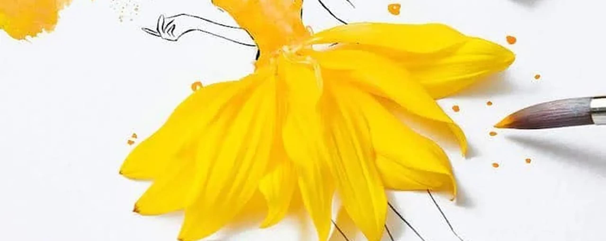 A fashion illustration where a sketched figure's skirt is formed from a real yellow flower's petals, with a paintbrush beside it