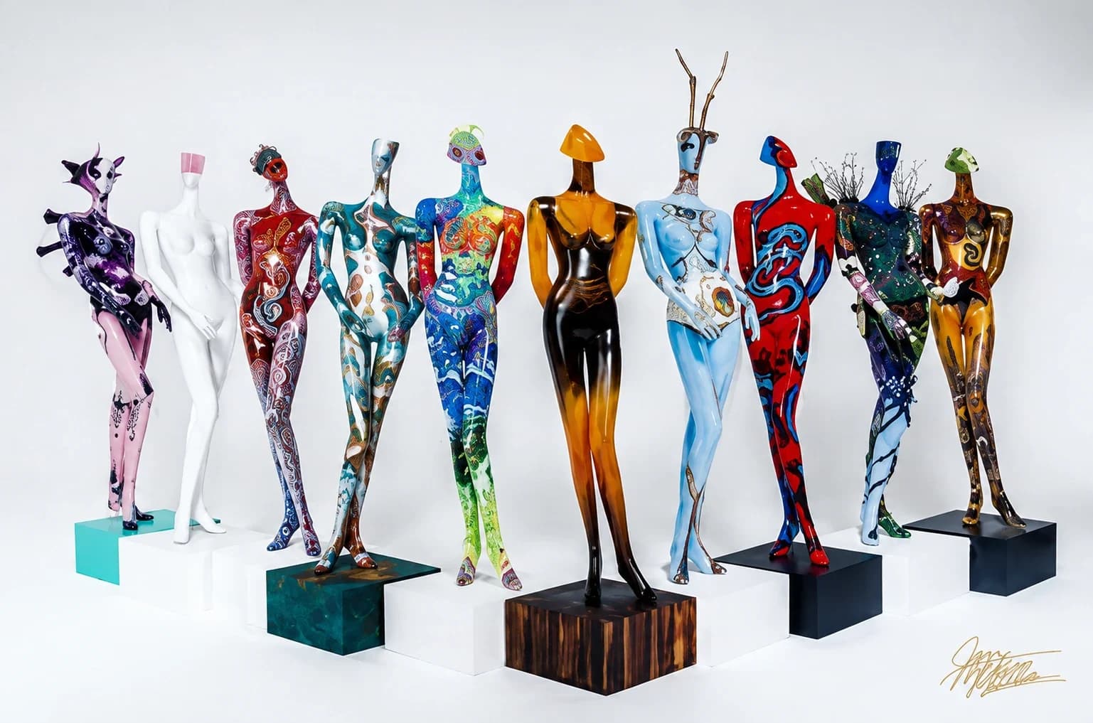 A row of full-size mannequins hand-painted by local artists, displayed on pedestals for the Mannequin Project
