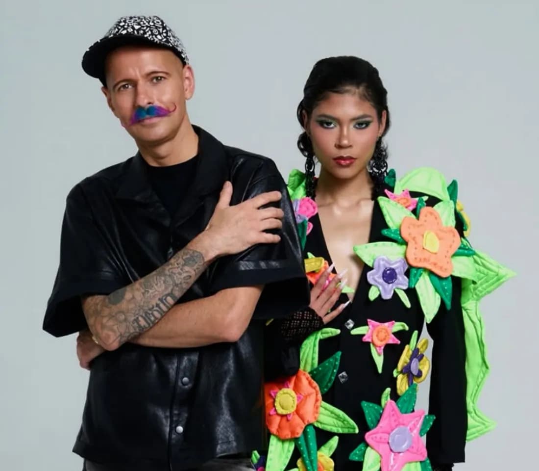 Two models presenting a designer look featuring a floral appliqué jacket